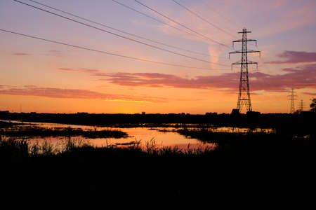 Silhouette electric high power pylon and wires at red sunset. 2020 the Netherlands