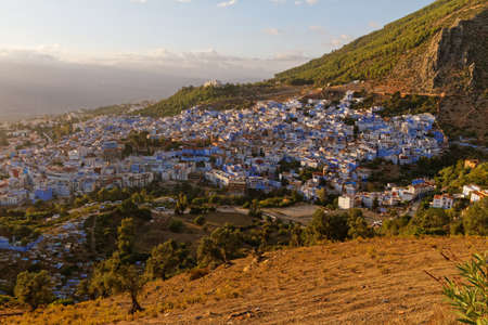 Sunset view of Chefchaouen, Morocco with mountain and palm tree. Blue city. Traveling through Morocco. Warm coloursの写真素材