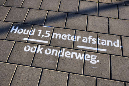 Drawing on pavement in Dutch, Keep 1.5 meter social distancing, also on the road. Coronavirus measures and rulesの写真素材