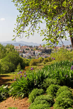 Scenic white mountain village in a green frame with plants, flowers and trees, warm summer light, Granada, Spainの写真素材