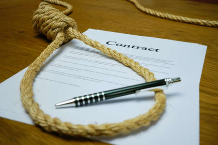 Contract with pen and rope tied in hangmans noose. Strangulation contract, unfair agreement.の写真素材