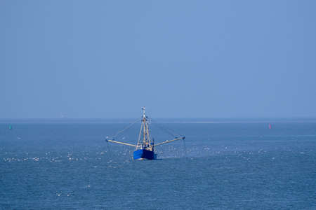 Ameland, Netherlands-April,19,2021: Fishing boat, nets and seagulls on the Wadden Sea. Fisherman conflict escalates: British, French and Dutch arguing over North Sea and electric pulse fishingの写真素材