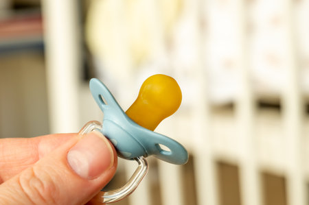 Close up of baby pacifier in the hand of a father.