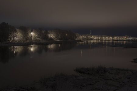 river at night with snow covered treesの写真素材