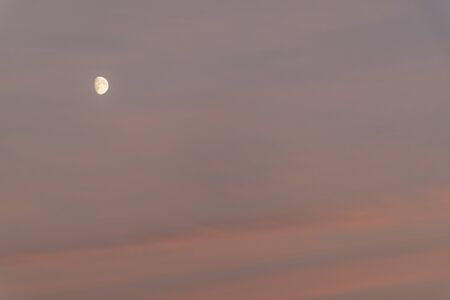 the moon at sunset and coloured skyの写真素材