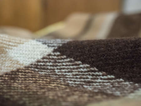 Selective focus on brown blanket texture close up. Blanket texture pattern against blurred bright...