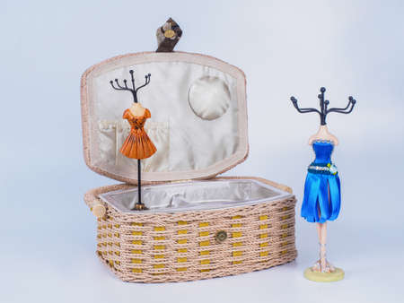 Composition of opened beige-coloured box with two stands for bijouterie isolated on white background. Handmade decoupage box for needlework. Orange mannequin styled stands for bijouterieの写真素材