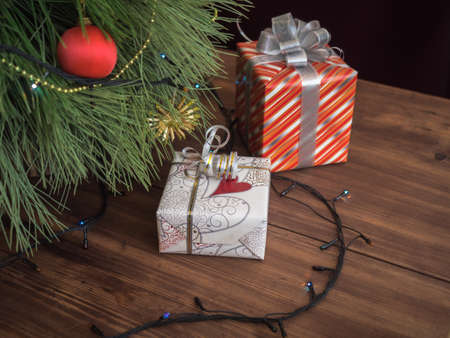 Green Christmas tree decorated with toys and garland with led lights. Boxes with gifts. Christmas...