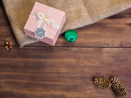 Vintage gift box, fir cones, Christmas toy, ribbon with bow on wood and burlap vintage background, photo top view. Copy space for text. Top view, Studio photographyの写真素材