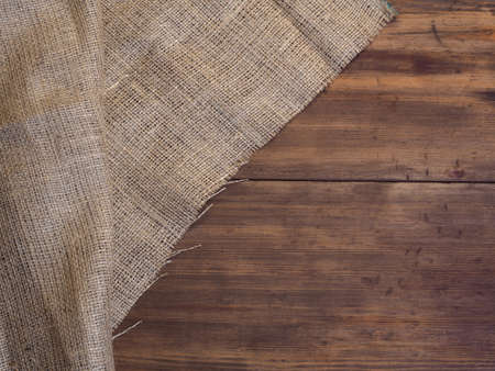 Arrangement of old wooden boards and burlap vintage background, photo top view. Burlap hessian...