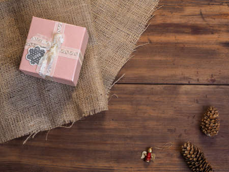 Vintage gift box, fir cones, Christmas toy on wood and burlap vintage background, photo top view. Copy space for text. Top view, Studio photographyの写真素材