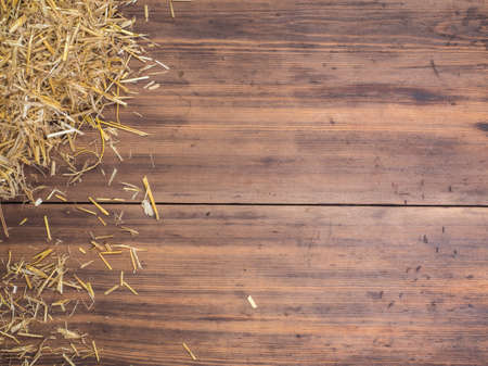 Rural eco background with and straw on the background of old wooden planks. The view from the top. Creative background for greeting cards, menu or advertisingの写真素材