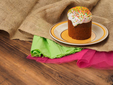 Easter cake on ceramic bowl. Background with colored mesh and paper. Russian and Ukrainian, orthodox...