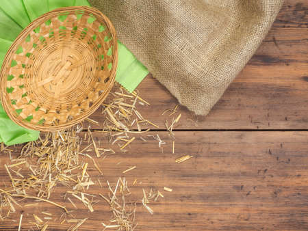 Top view, rustic background with a basket, colored green paper, burlap and straw, hay. Rural, eco background with place for your design.の写真素材