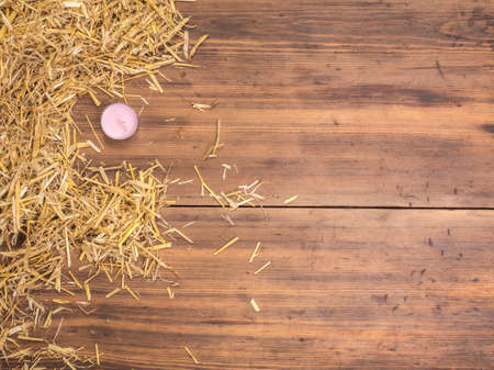 Rural eco background with colored candle and straw on the background of old wooden planks. The view from the top. Creative background for greeting cards, menu or advertisingの写真素材