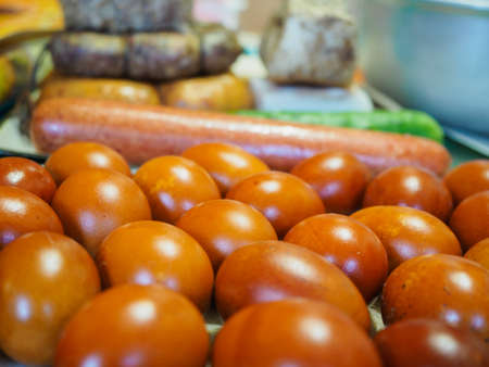 Easter background, brown chicken eggs, homemade sausages, boiled bacon with pepper, spices. Close-up view with soft focus and blur. Traditional Russian, Ukrainian homemade food for the Orthodox Easterの写真素材