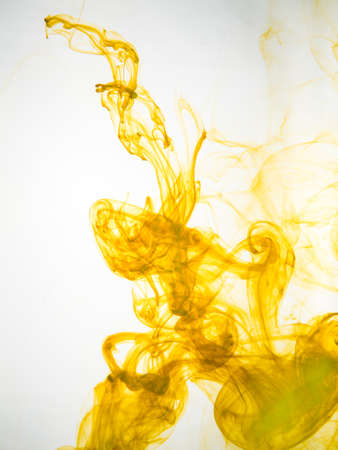 Ink swirl in a water on white background. The paint splash in the water. Soft dissemination a droplets of colored ink in water close-up. Abstract background. Explosion of color splashes acrylic ink.の写真素材