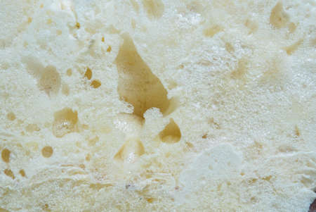 Texture of the foam. Construction foam, surface of polyurethane close-up. View of top, Macro...