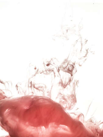 Ink swirl in water isolated on white background. The paint in the water. Soft dissemination a droplets of pink ink in water close-up. Abstract background. Explosion of splashes yellow acrylic ink.の写真素材