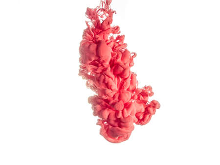 Ink swirl in water isolated on white background. The paint in the water. Soft dissemination a droplets of pink ink in water close-up. Abstract background. Explosion of splashes yellow acrylic ink.の写真素材