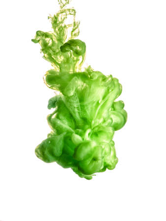 Ink swirl in water isolated on white background. The paint in the water. Soft dissemination a droplets of green ink in water close-up. Abstract background. Soft focus.の写真素材