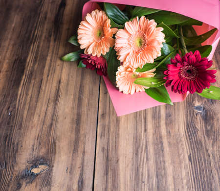 Gentle bouquet of flowers on old wooden background for congratulations, wedding flowers closeup. Decoration made of chrysanthemums, daisies, green plants for birthday card. Selective soft focusの写真素材