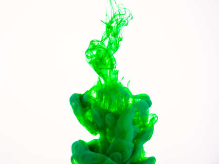Image of green paint dissolving into water. Deteiled photo of green paint dropped into liquid, abstract background. Green acrylic explosion in liquid. Colourful splash photographed while in motionの写真素材