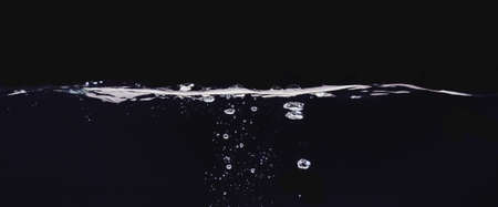 Water bubbles isolated on black background, close up view. Rippling liquid surface, an abstract...