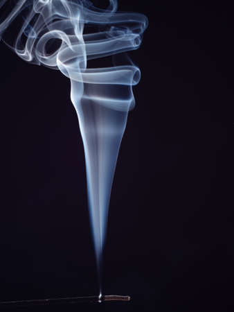 White smoke from burning incense isolated on black background, close up view. Abstract background, smoke brush. Eastern sweet smell for meditation. Fragrance for relaxationの写真素材