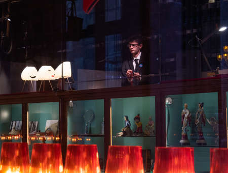 Barcelona, Spain - august 2019: colourful souvenir shop, medium view. Row of red lamp shade and souvenir gifts on shelves. man behind show-case. Selective soft focus. Blurred backgroundのeditorial素材