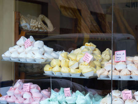 Barcelona, Spain - august 2019: confectioners shop in city center. Pastry on shelves, close up view. Interior of cake-shop, view from street. Selective soft focus. Blurred backgroundのeditorial素材