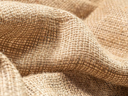 Crumpled brown sackcloth, an abstract background. Close up view on brown burlap textile. Texture of burlap fabric. Selective soft focus. Blurred backgroundの写真素材