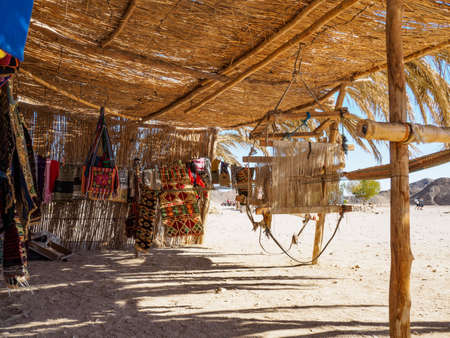 Shed made of bamboo and reed in egyptian desert, medium view. Exotic fabrics for sale in bamboo shed. Bedouin village. Selective soft focus. Blurred backgroundの写真素材