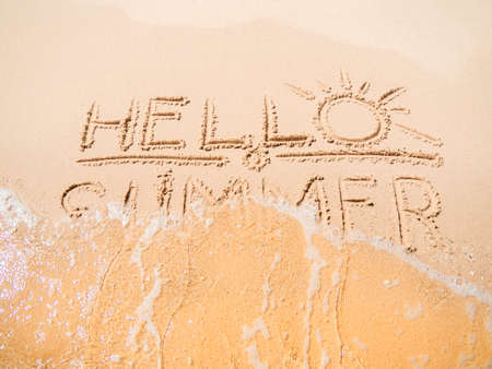 Sea wave erasing inscription on yellow sand, close up view. Egypt in february, Red Sea. Selective soft focus. Blurred background