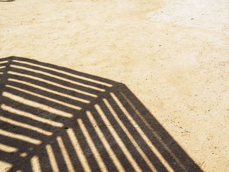 Shadow of beach umbrella on yellow sand, medium view. Egyptian beach in february. Abstract...