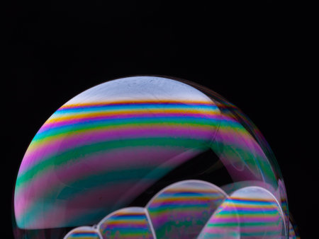 Set of soap bubbles with color gradient isolated on black background. Close-up Macro shot