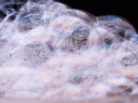Soap bubbles close-up. Abstract pattern with soft focus. Macro shot of soap foam on blurred black backgroundの写真素材