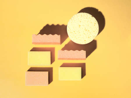 Geometric pattern with domestic sponges on orange background. Top down view. Abstract composition...
