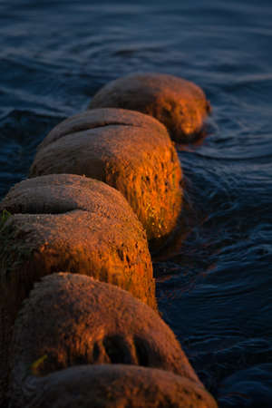 breakwater posts in sunsetの写真素材