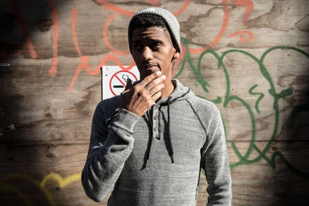 A portrait of a young hipster posing infront of a wall of Graffiti. Shot in Brooklyn, New York City during the Autumn of 2016.の写真素材