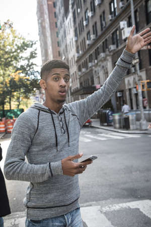 A young, black hipster poses for a candid photograph in NYC. Shot during the autumn of 2016.の写真素材