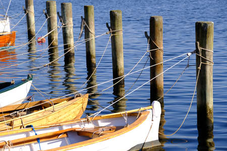 Old wooden boats are moored in the harbor