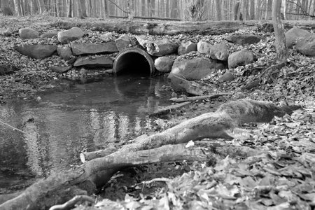 Black and white A stream is led through a pipeの写真素材