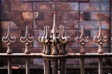 a spiky iron railing pattern with an old weathered rosy multicolored background