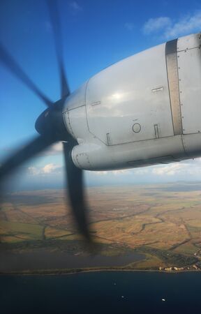 Turbo Prop Plane Flying Over Island Coastlineの写真素材