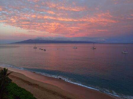 Morning Sunrise Aerial View over Maui Hawaii Beach with Pink Clouds Reflected on Vast Ocean and...