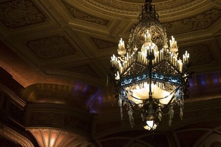 Chandlier with Decadent Details Hangs from Theater Ceilingの写真素材