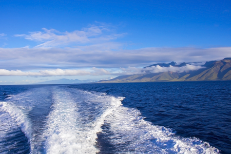 Boat Wake Makes lines at Sea with Island in Backgroundの写真素材