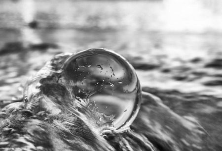 Black and White Close Up Sea Water Splashes Around Glass Ballの写真素材