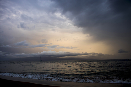 Dramatic sunset sky reflecting in ocean surface as hurricane storm approaches islandの写真素材